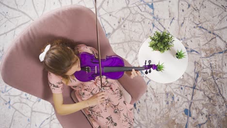 Musician-Woman-sitting-on-sofa-at-home-and-playing-violin.